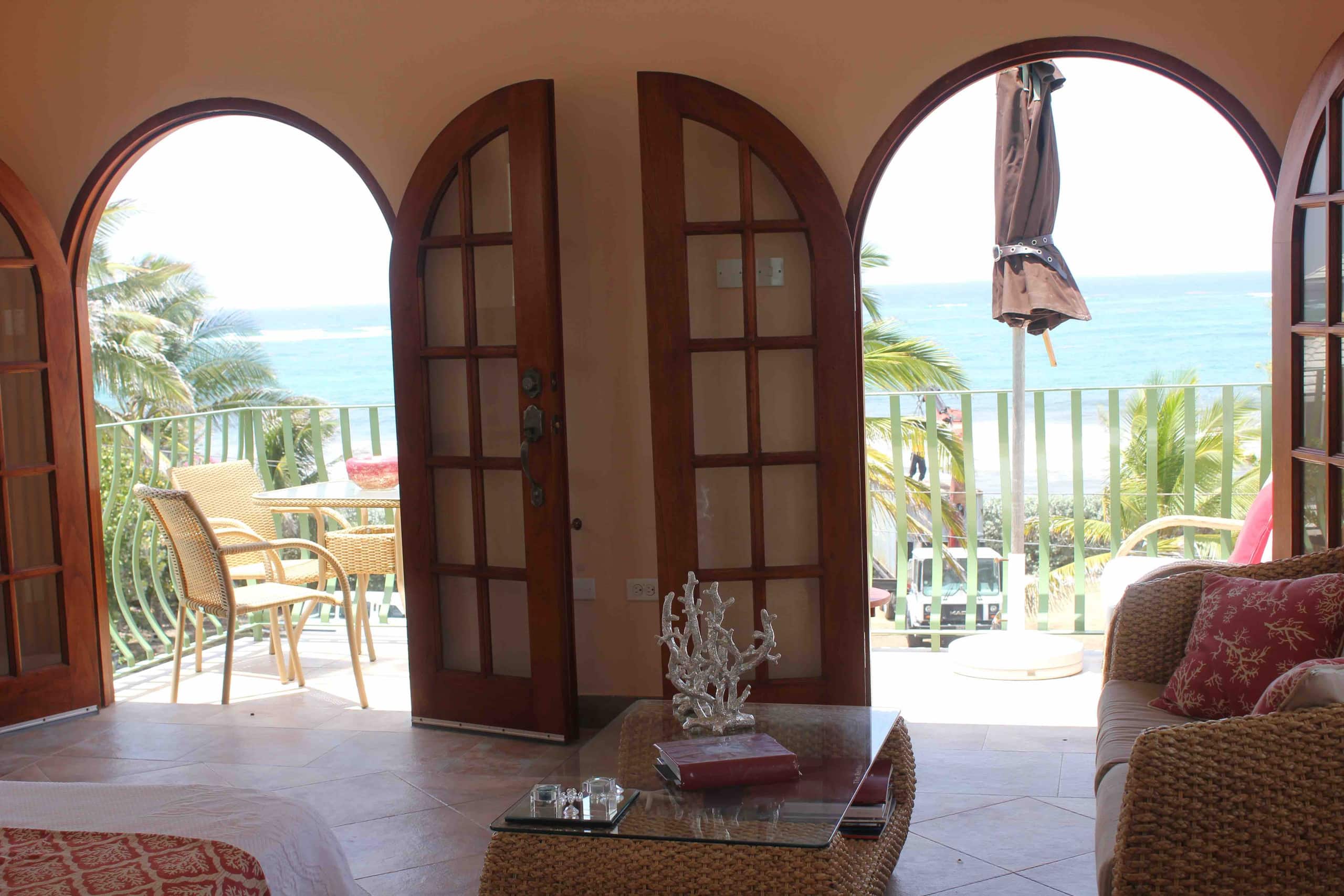Sea Mist Upper living area opening through wooden doors to a balcony and blue ocean